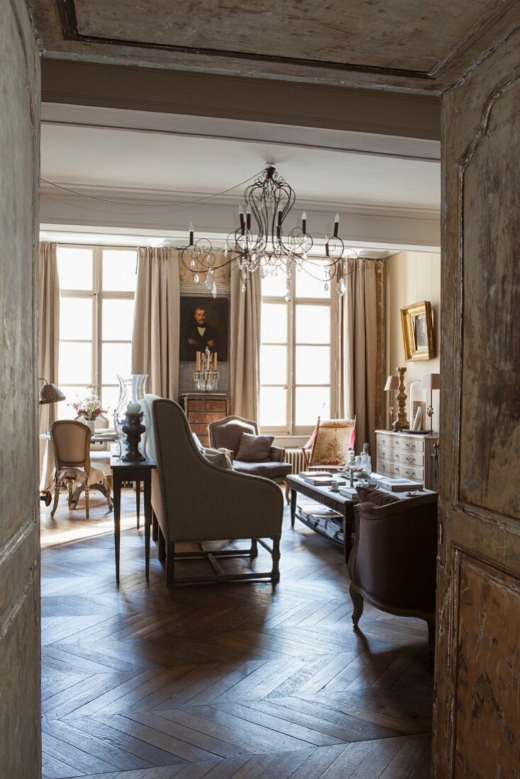 Blick in eleganten Wohnraum im französischen Stil mit Antikmöbeln und Kronleuchter