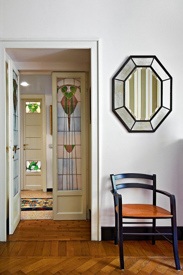 Chair below mirror; view of interior door with art nouveau glass panels in hallway