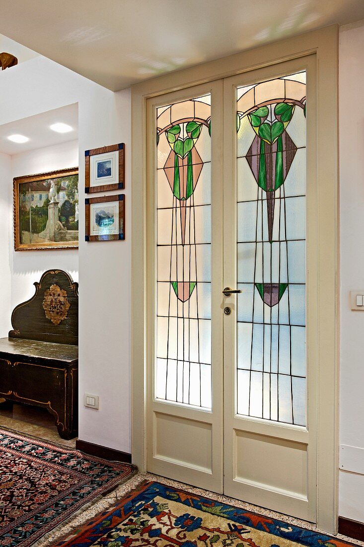 Double doors with art nouveau, stained glass panels in traditional interior