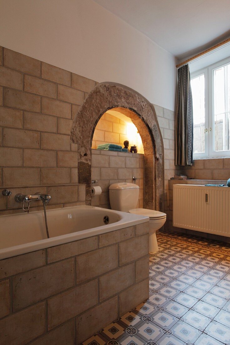 Rustikales Badezimmer mit altem Torbogen und Zementfliesen
