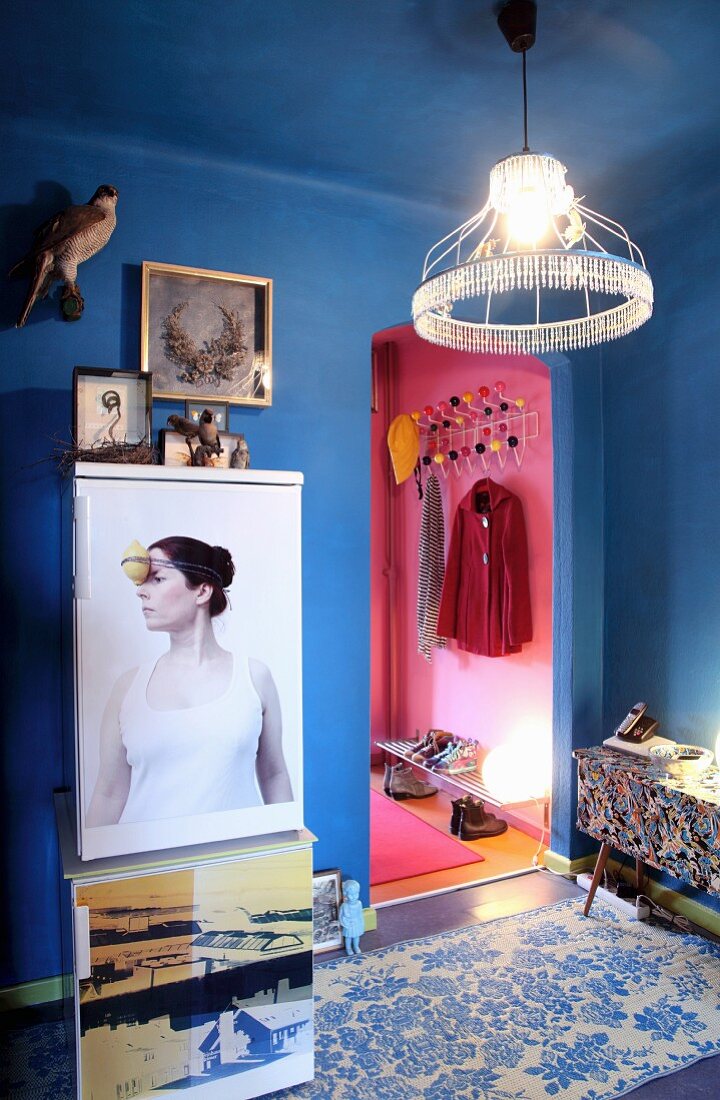 Fridge decorated with printed magnetic foil and wire lampshade with beaded edge in blue-painted hall