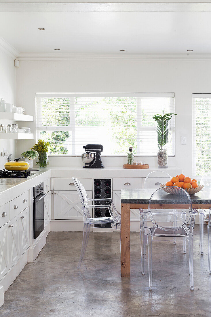 White kitchen, open shelves and acrylic chairs