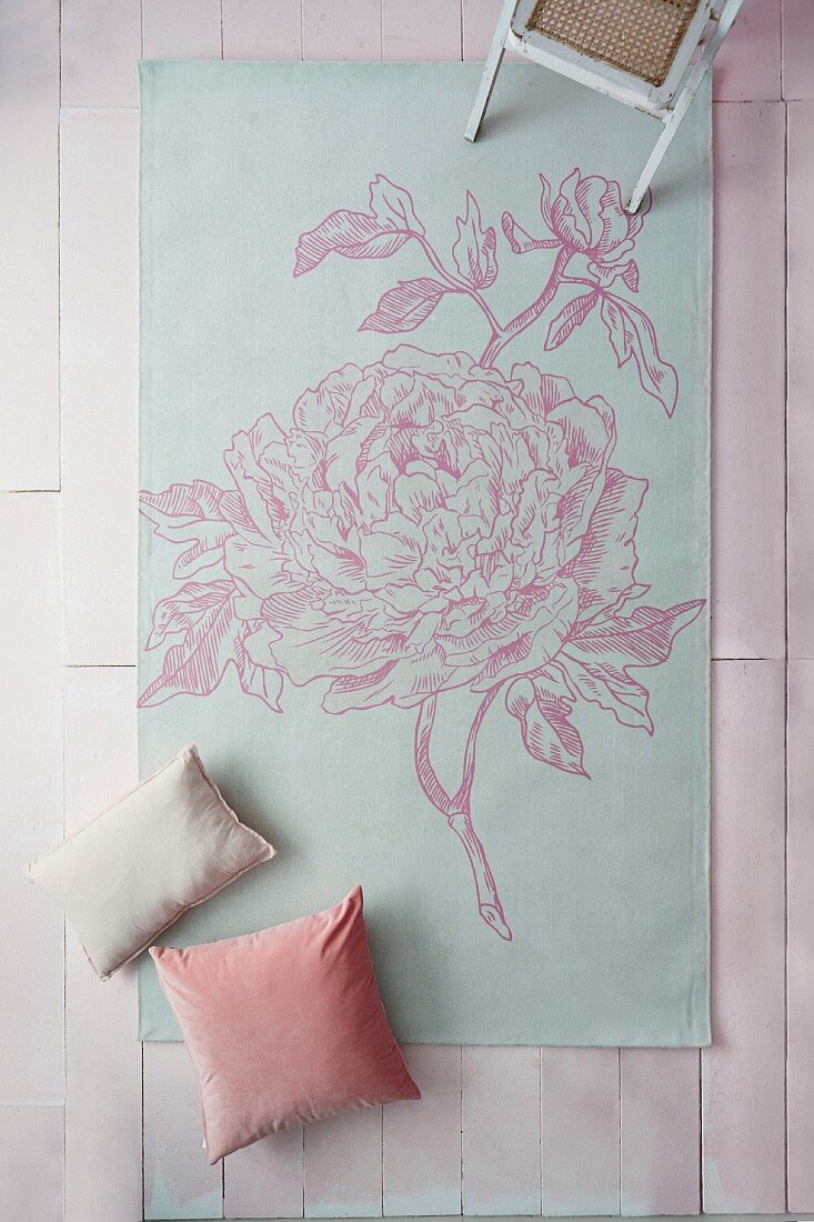 Rug printed with floral motif on pale pink surface