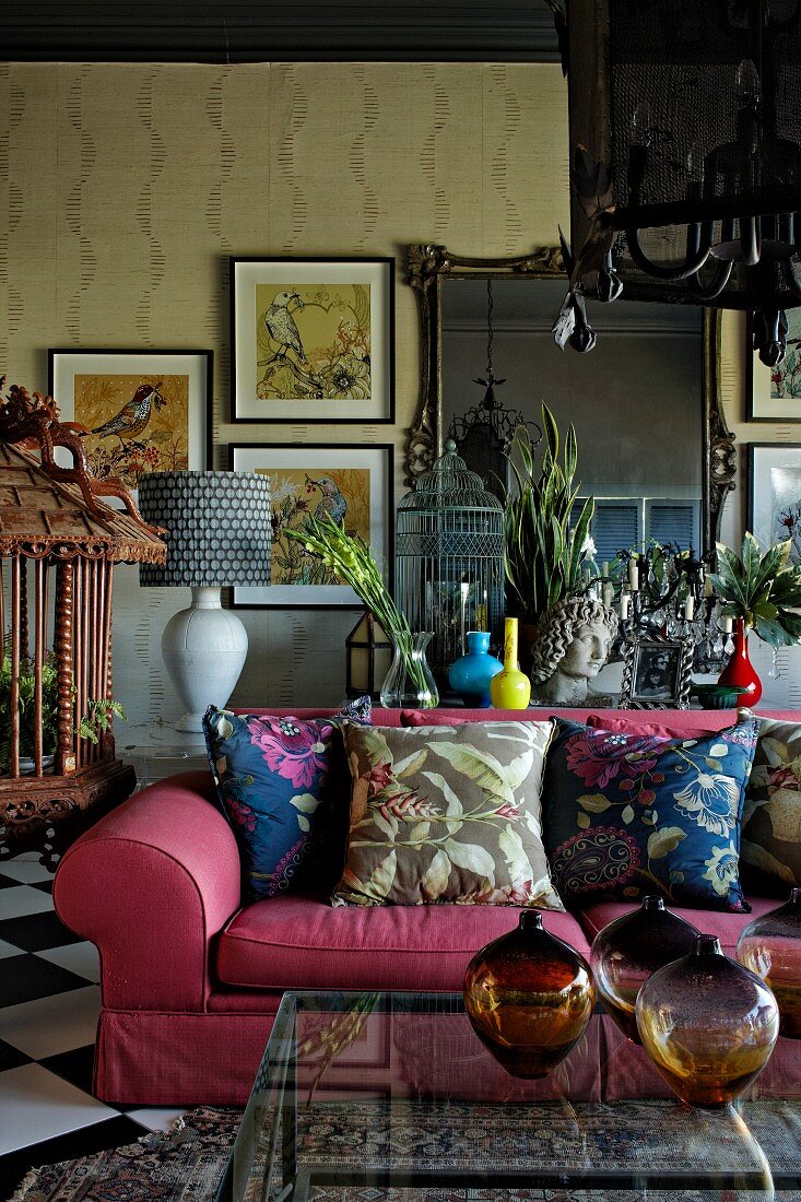 Wohnraum mit pinkfarbener Polstercouch, Ethnokunst und eklektischem Flair