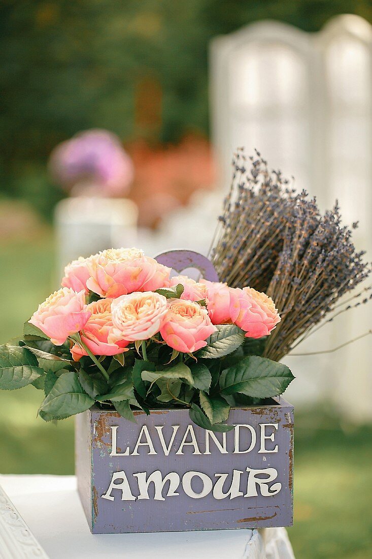 Roses and dried lavender in vintage, purple wooden crate with lettering