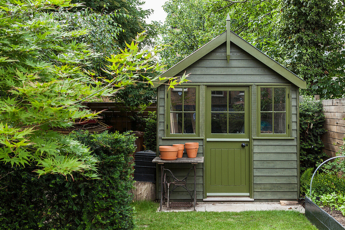 Dark green shed with lattice windows