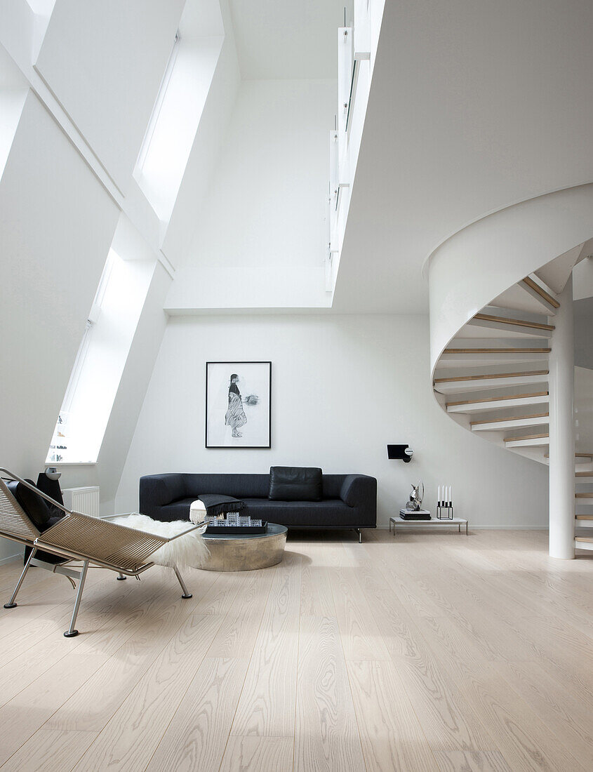 Spiral staircase in modern, double-height living room with sloping wall