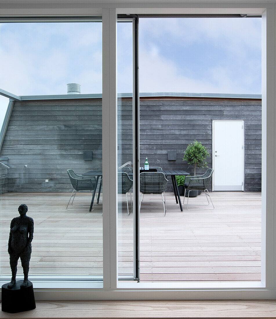 View through open terrace doors of dining table on roof terrace