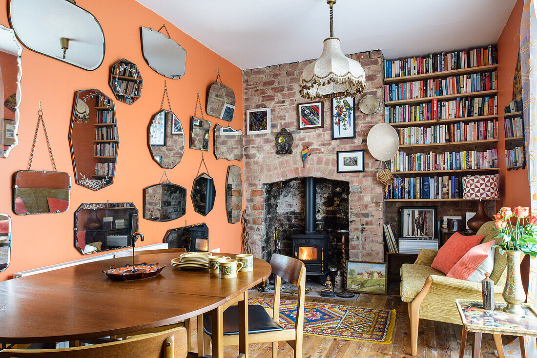 Collection of mirrors and log burner in fireplace in dining room