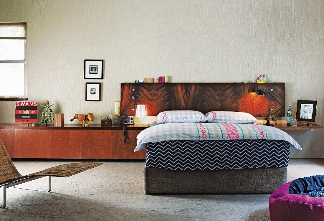 Bett mit Kopfteil aus Furnierholz und einem Sideboard als Nachttisch