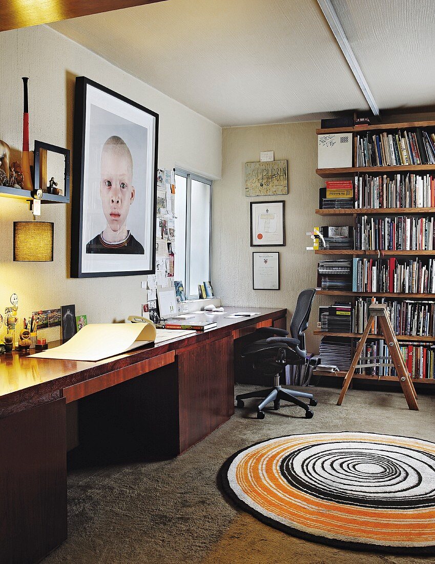 Arbeitszimmer mit doppeltem Schreibtisch, Bücherregal und rundem Teppich