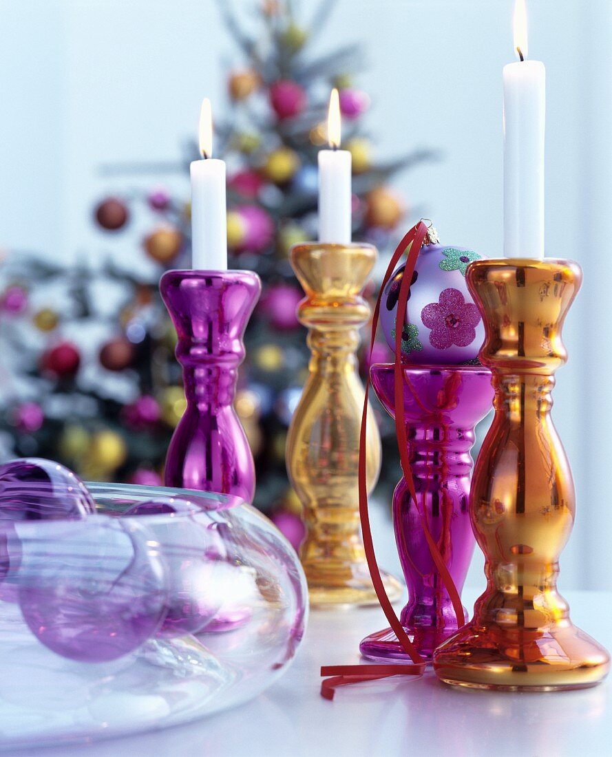Festive arrangement of deep pink and gold candlesticks made from silvered glass