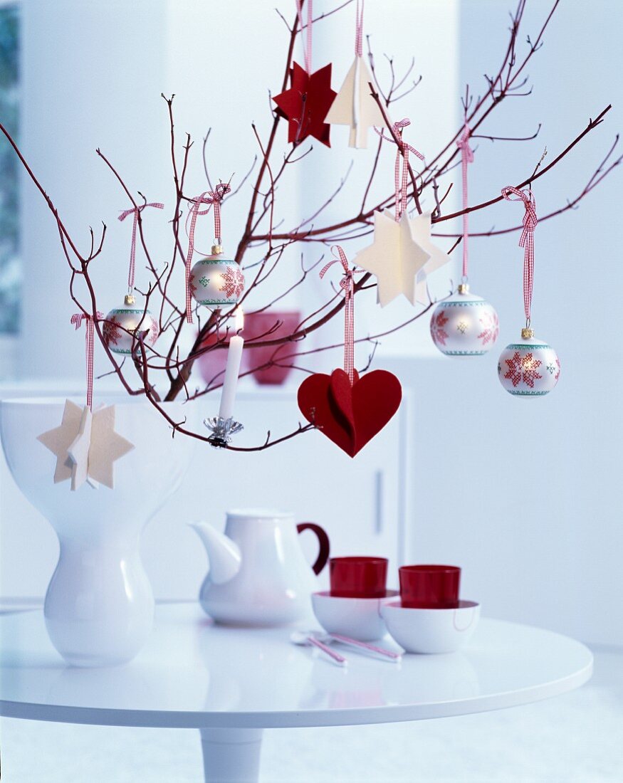Vase of branches decorated with baubles and hand-made red and white felt pendants