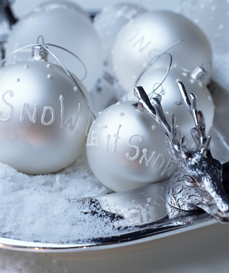 Silver Christmas tree baubles with decorative lettering on silver plate