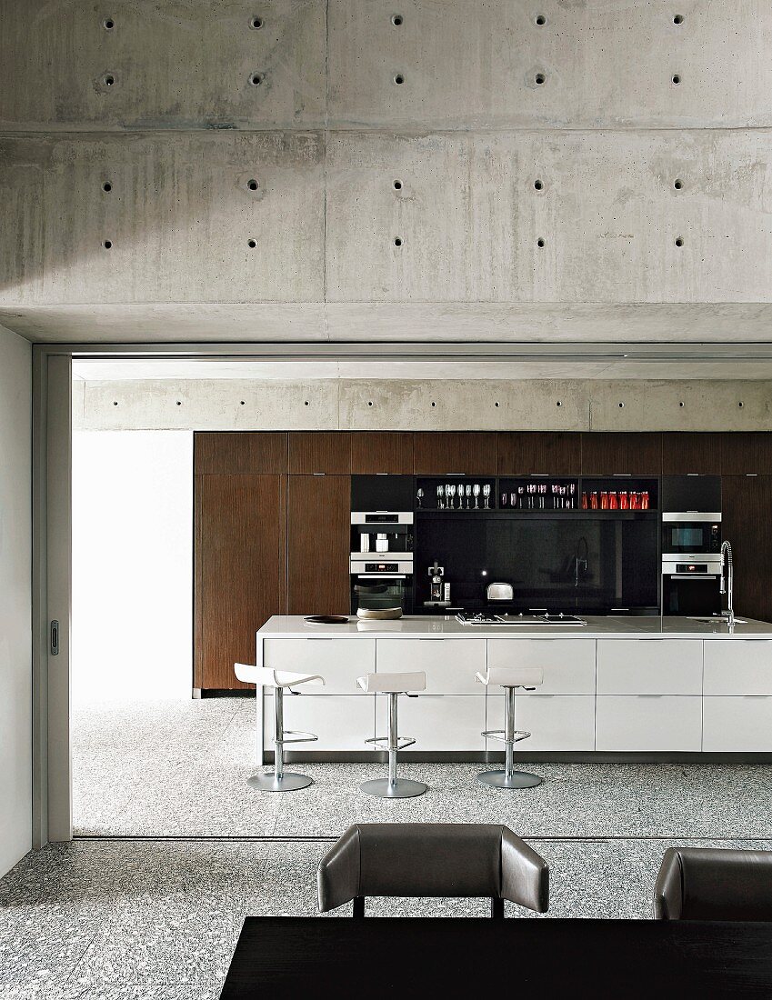Offene Küche mit moderner Kochinsel, Wände aus Beton