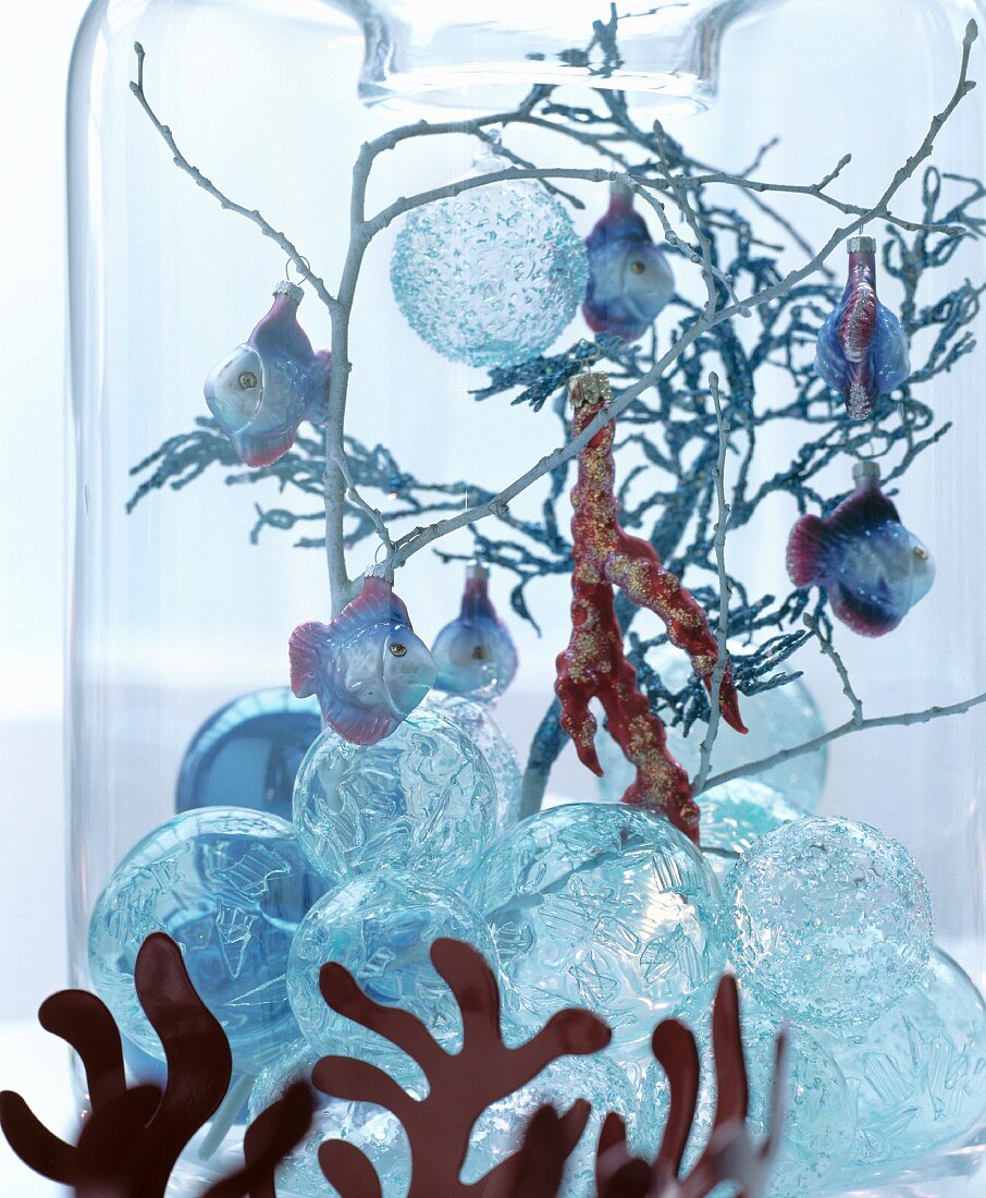 Märchenhafte Weihnachtsdeko: Glaskugeln, Zweige und Dekofische in Glasvase