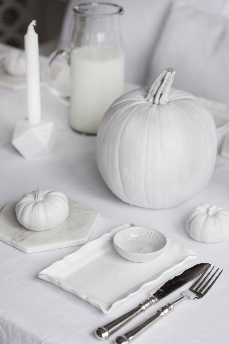 Gedeckter Tisch mit Halloweendeko in Weiß