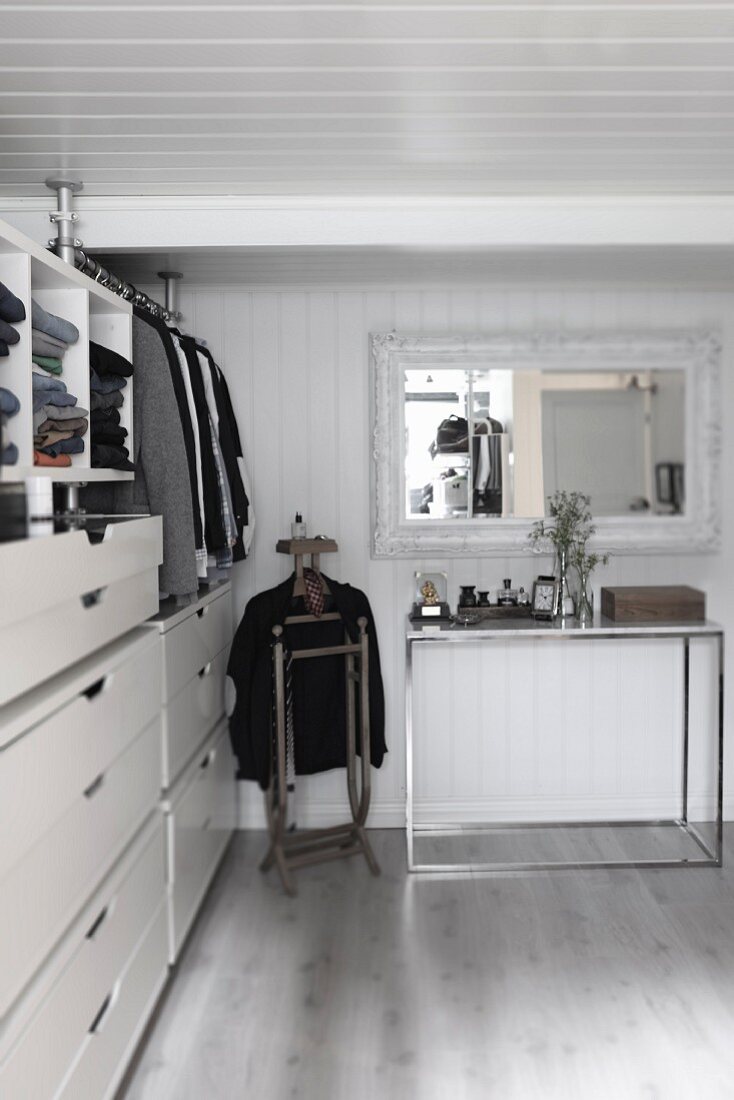 Einbauschrank mit Schubladen in Ankleide, weiße Holzverschalung an Wand und Decke