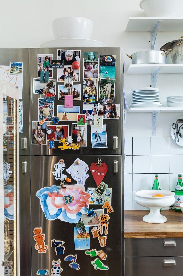Fotosammlung an Edelstahl Kühlschrank mit Magneten angeheftet, neben Küchenzeile und Wandboard