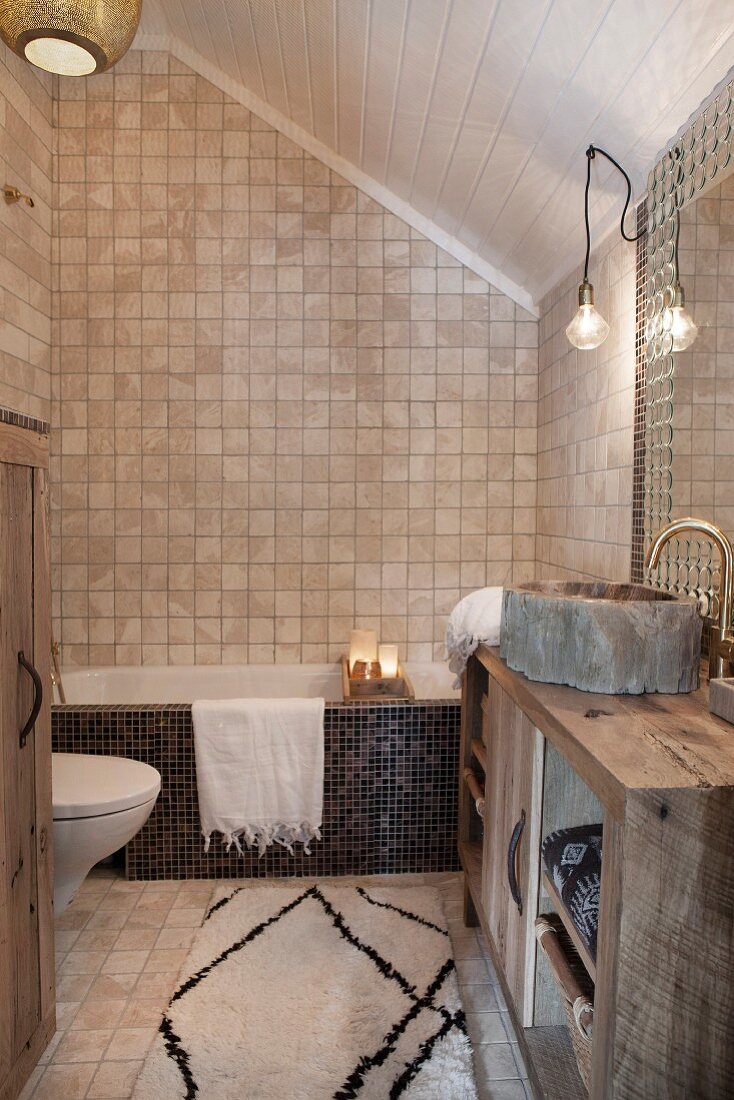 Orientalisches Badezimmer unter dem Dach mit Mosaikfliesen und rustikalem Waschtisch