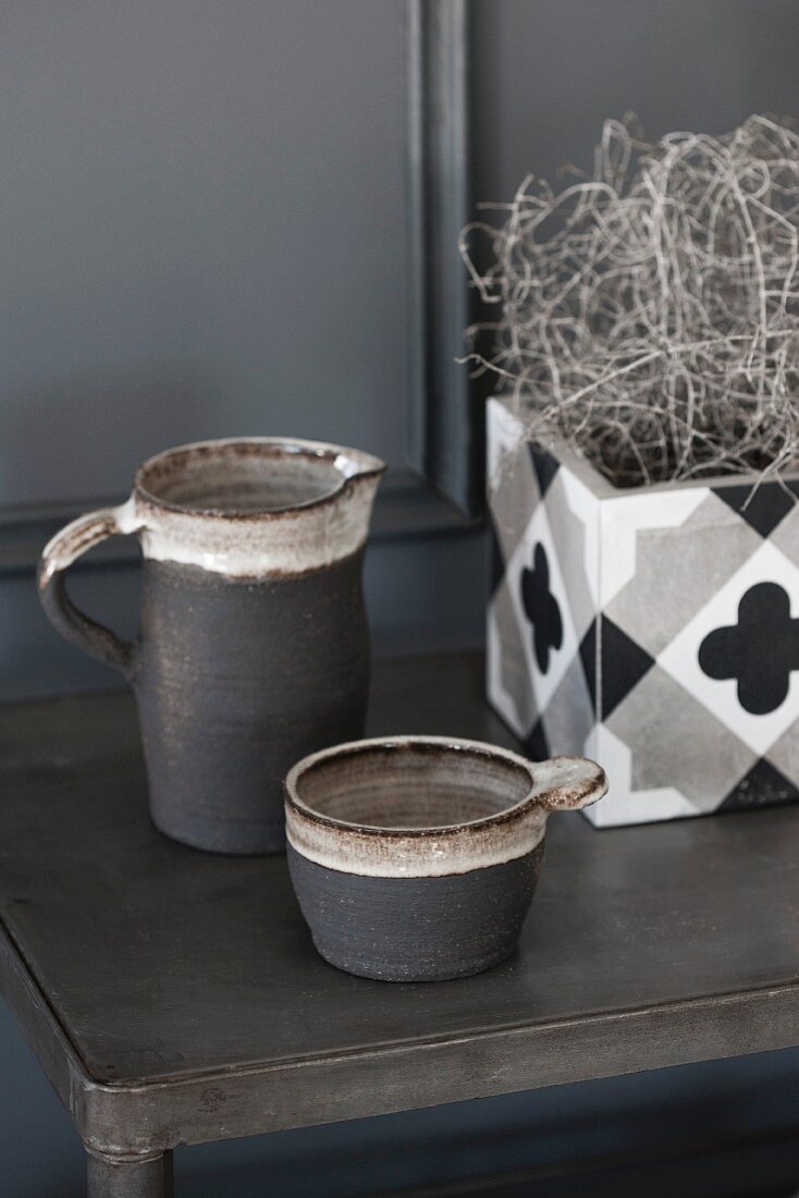 Grey jug and beaker next to planter with geometric pattern