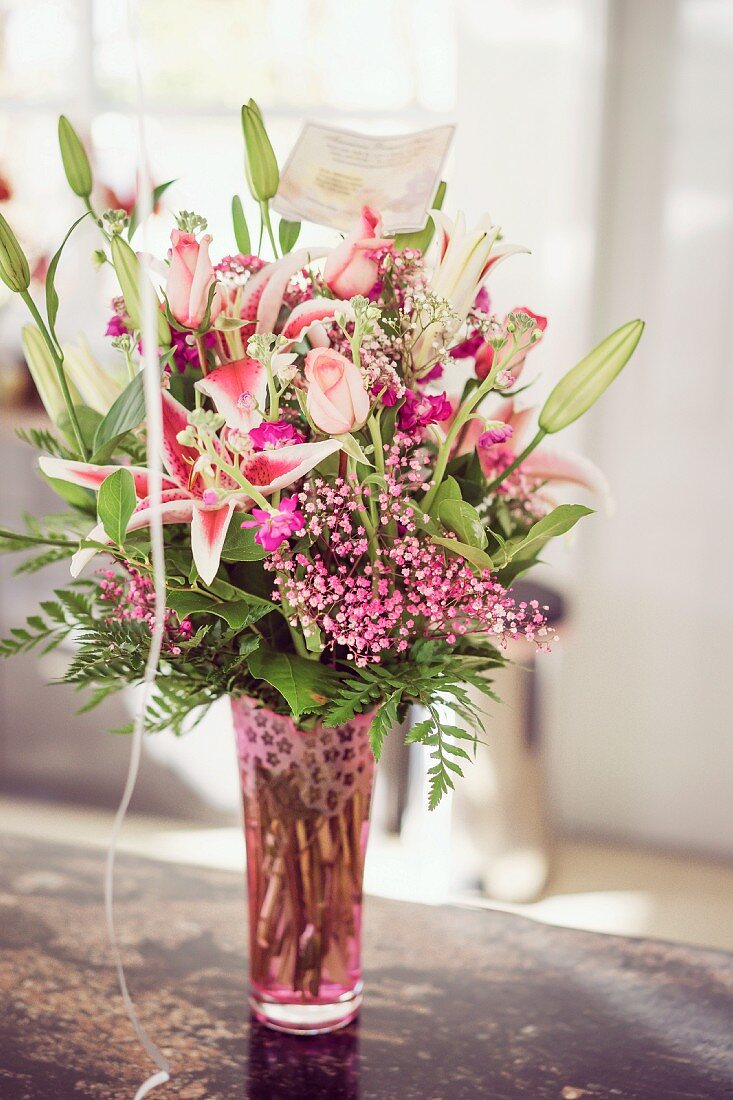 Festive, pink flower arrangement in retro glass vase