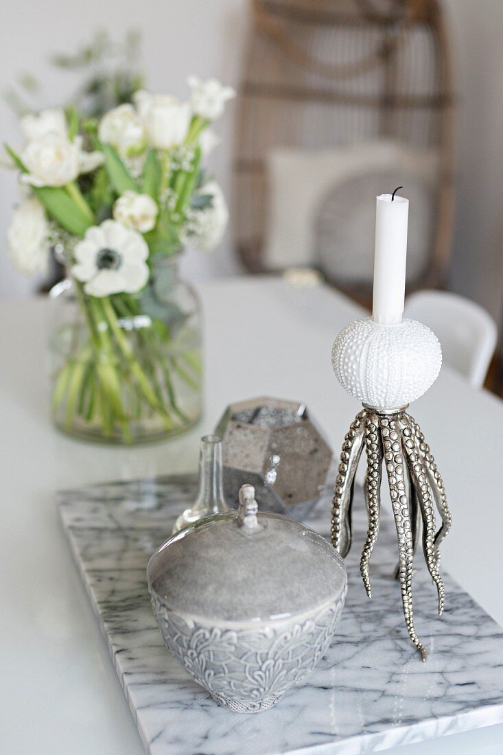 Tin and maritime candlestick on marble tile on table