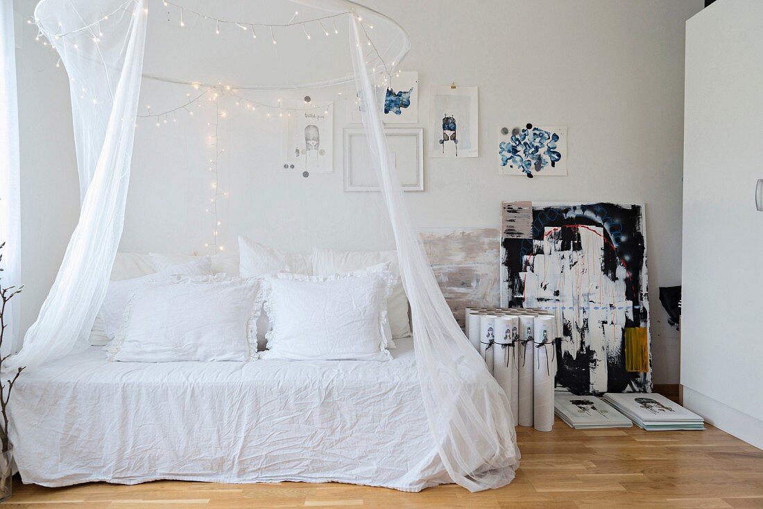 Betthimmel mit Lichterketten über einem romantischen Tagesbett mit Vintage-Kissen