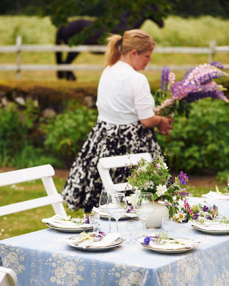 Gedeckter Gartentisch mit Wiesenblumen zum Mittsommerfest