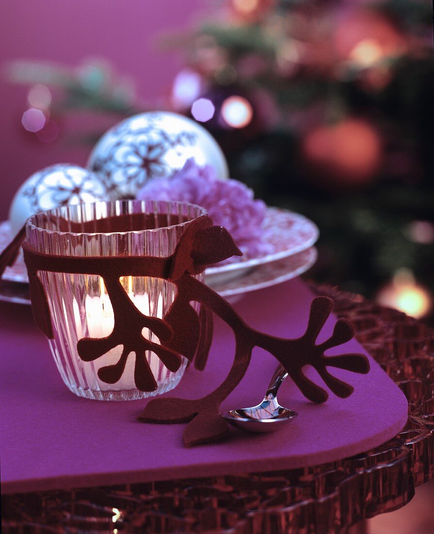 Glass tealight holder with felt decoration on table