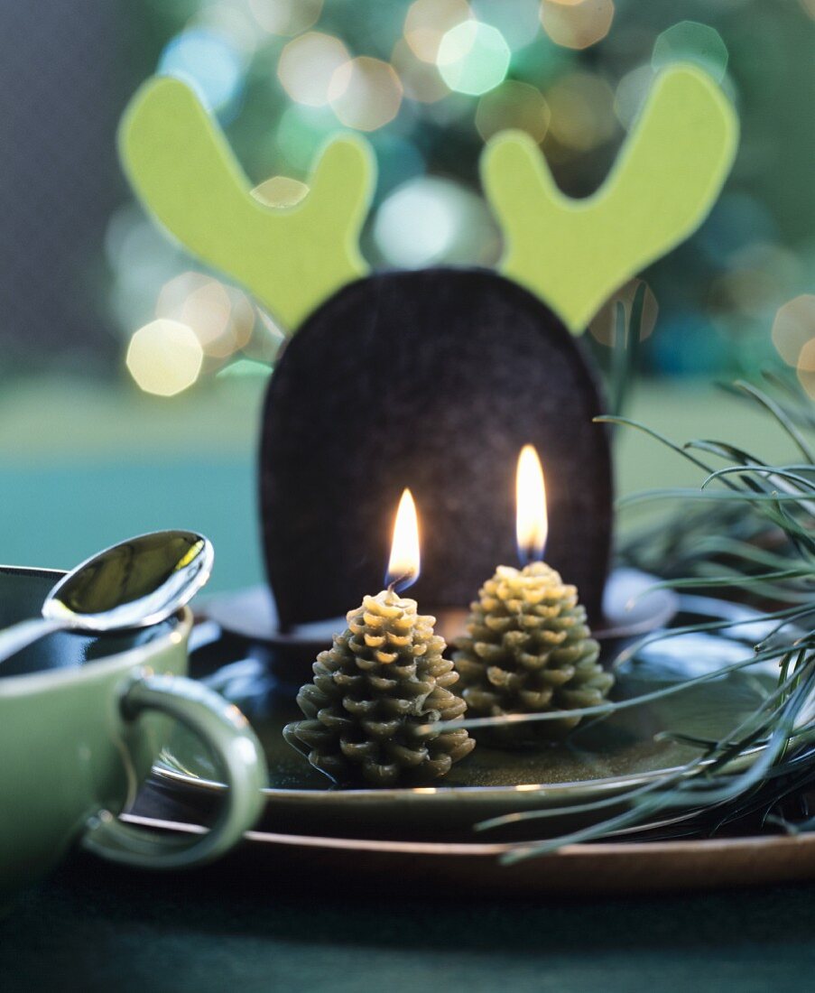 Place setting festively decorated with pine-cone-shapes candles