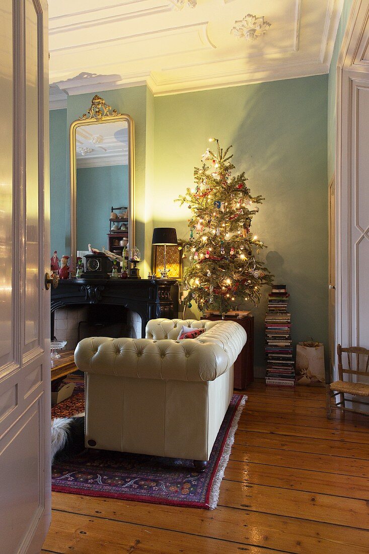 Blick ins Wohnzimmer mit geschmücktem und beleuchtetem Weihnachtsbaum