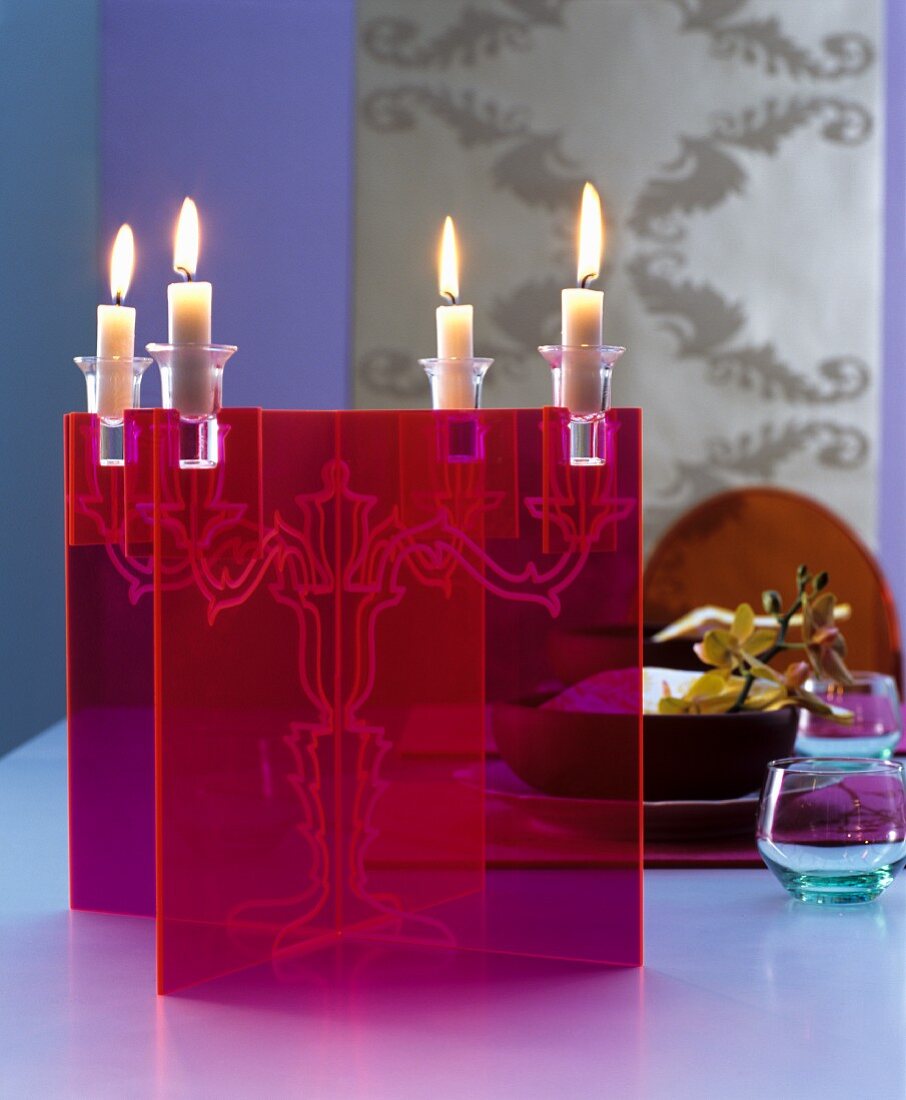 Lit candles in transparent, red candlesticks decorating table
