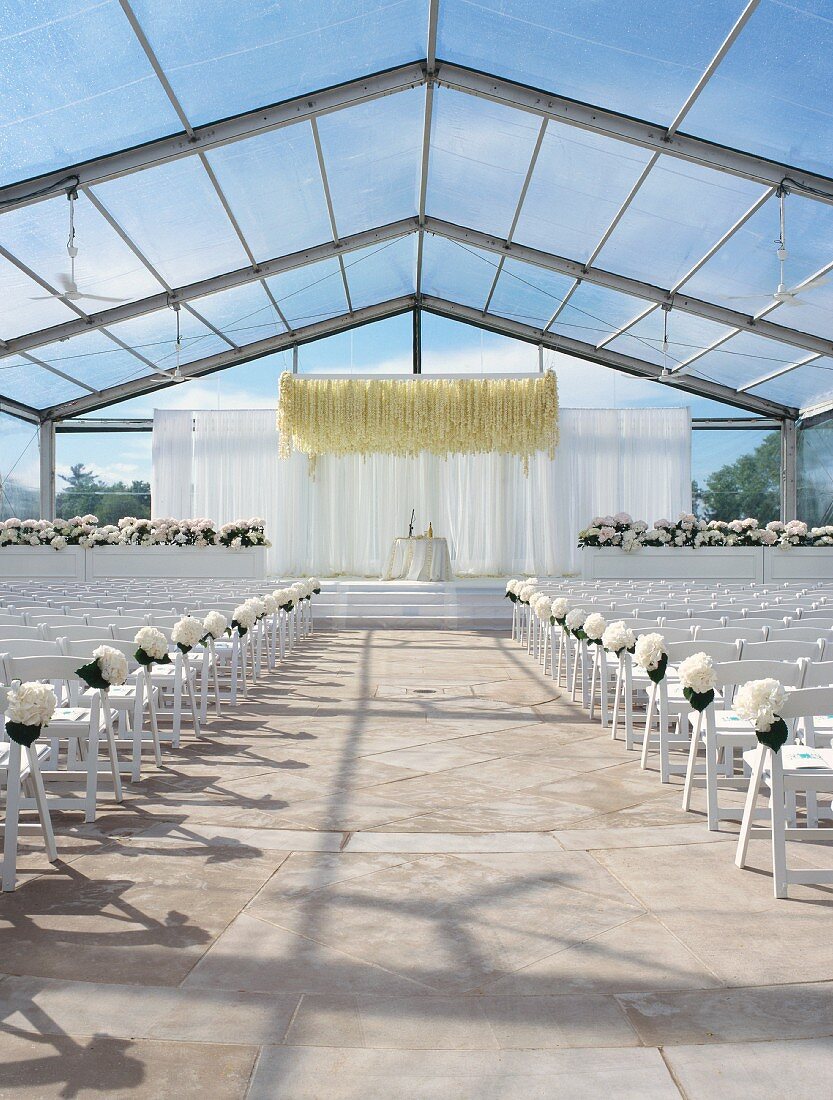 Festliche Hochzeitsdekoration in bestuhltem Glaspavillon