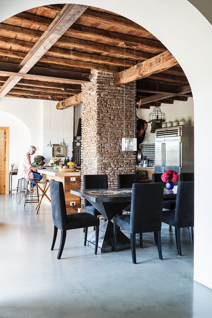 Offenes Wohnen in renoviertem italienischem Landhaus mit rustikaler Holzbalkendecke und Mauerpfeiler
