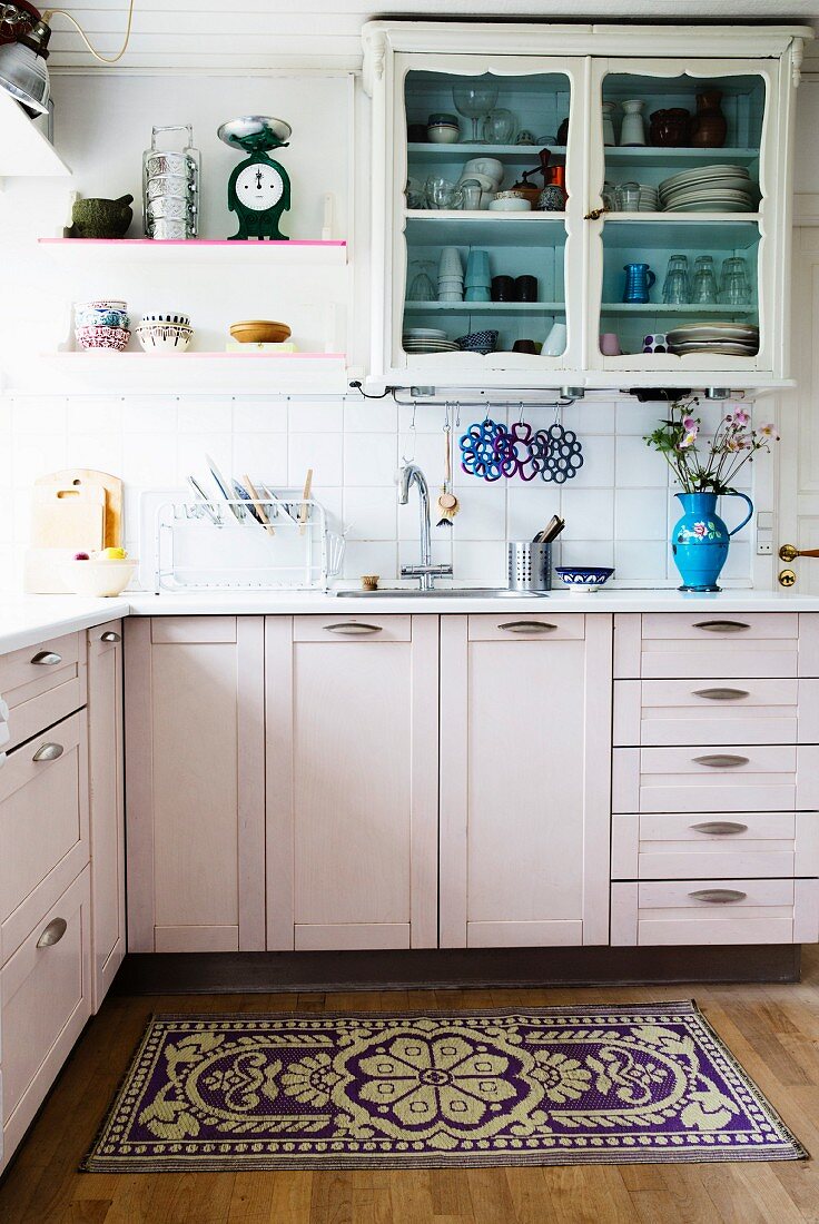 White-painted, L-shaped kitchen counter and wall-mounted, country-house-style cabinet