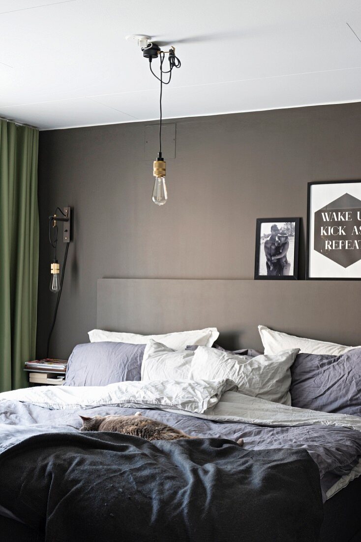Comfortable double bed in modern bedroom with grey-painted wall