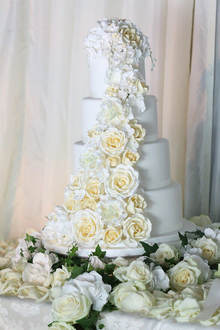 Mehrstöckige weiße Hochzeitstorte mit romantischer Rosendeko