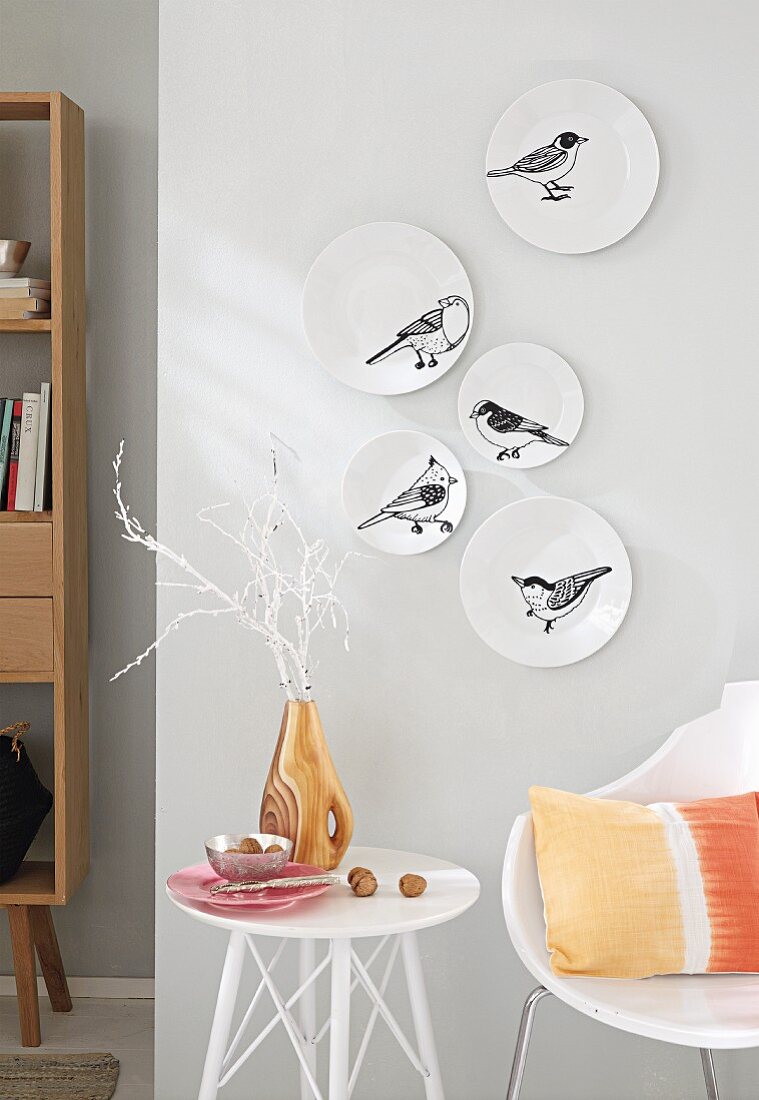 weiße Wandteller mit Vogel- Tattoos verziert
