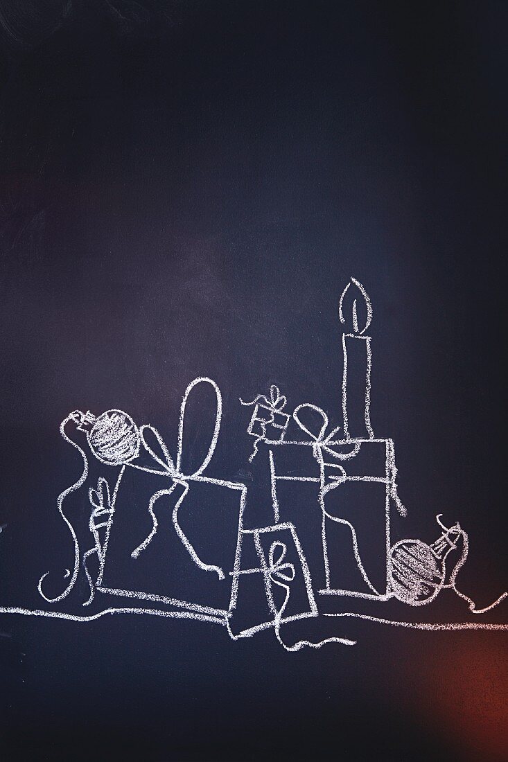 Gifts, candles and Christmas baubles drawn on chalk on a blackboard