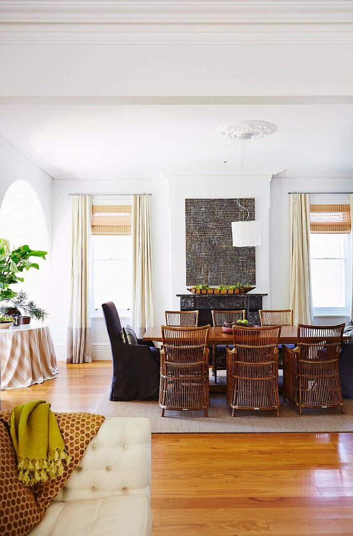 Dining table with wicker chairs in the spacious living room