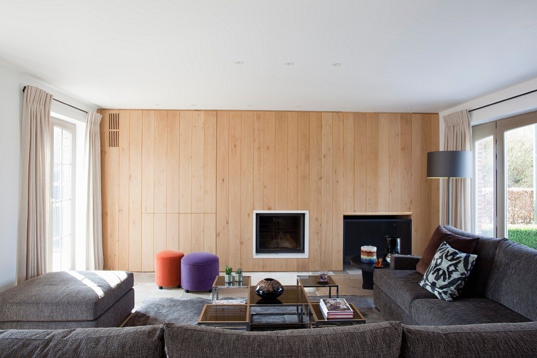 Wood-panelled wall with integrated fireplace and concealed cupboards in living room
