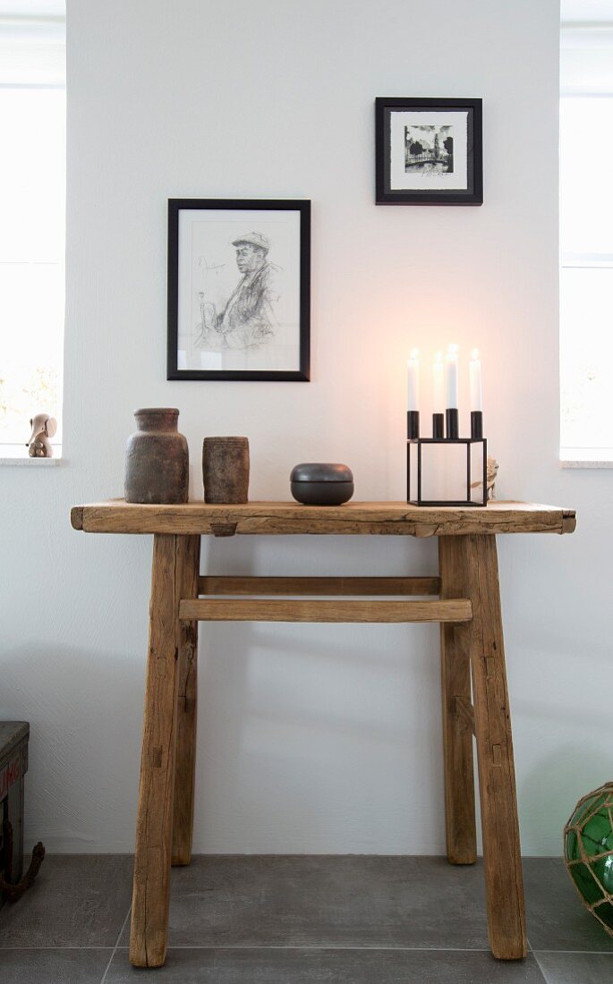 Keramikkunst und Kerzenhalter auf Wandtisch aus recyceltem Holz
