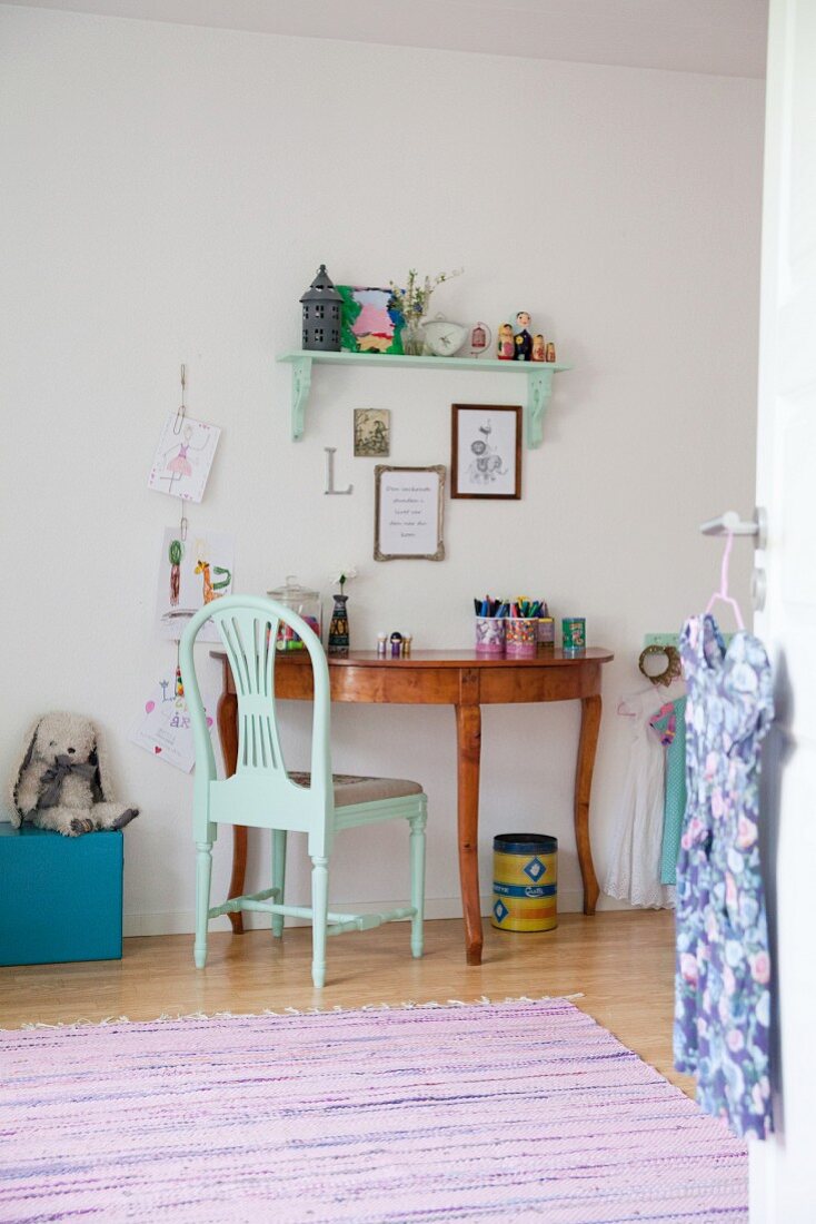 Turquoise chair in front of semi-circular desk in child's bedroom