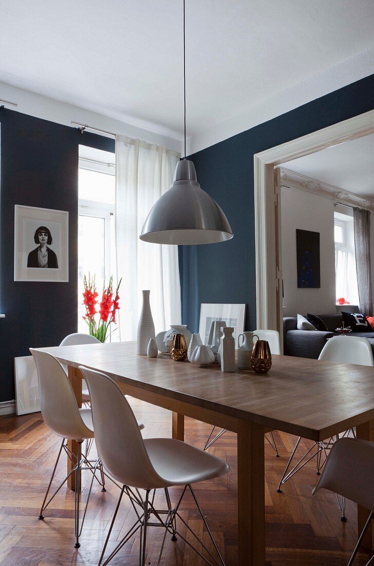 Wooden table in dining area of period apartment with dark grey walls