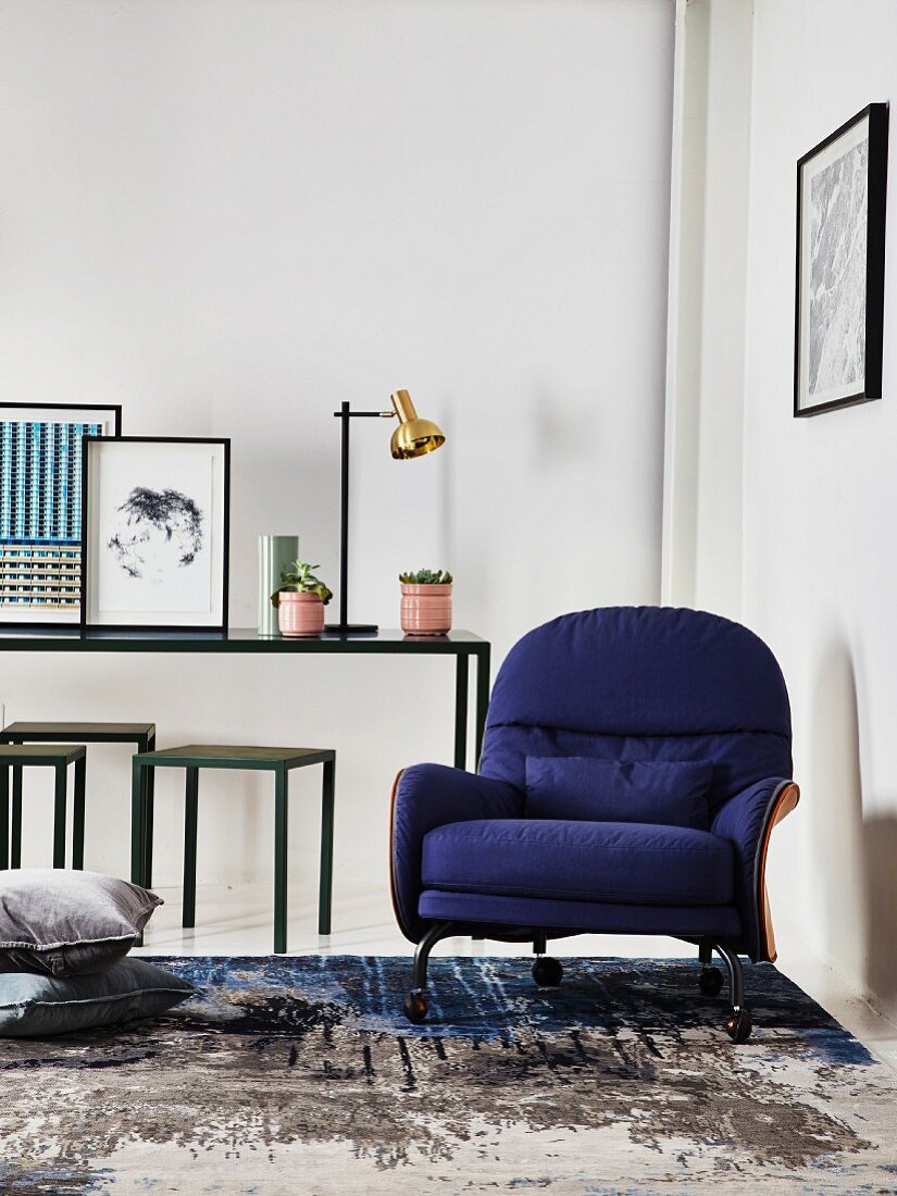 Blue armchair on vintage rug in front of slim table