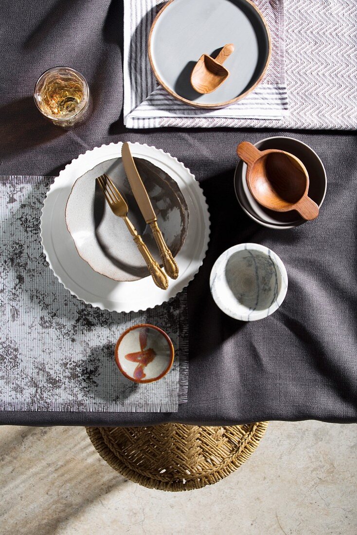 Gedeckter Tisch in Grautönen mit verschiedenem Geschirr