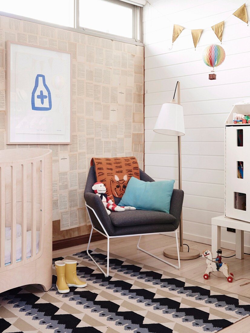 Kinderzimmer mit weißer Holzverkleidung, Designersessel und Fensterband
