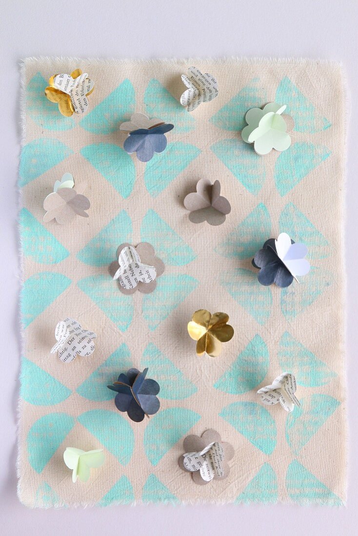 Small paper flowers on printed hand-made paper