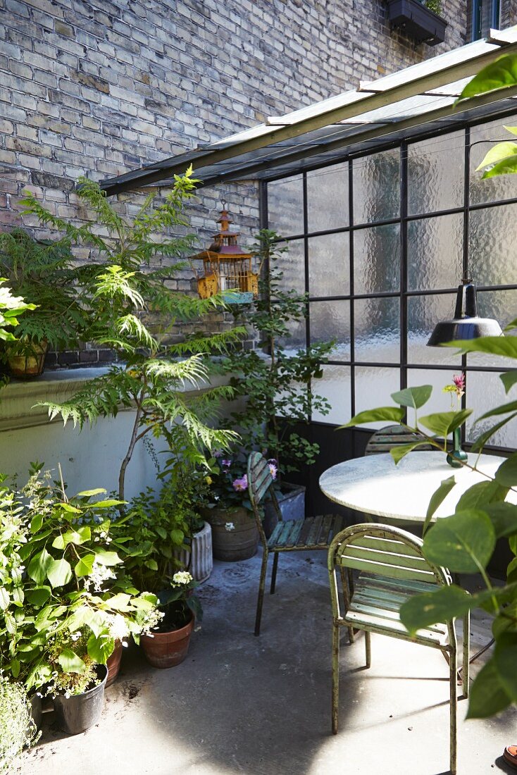 Vintage Gartenmöbeln und Grünpflanzen auf Terrasse